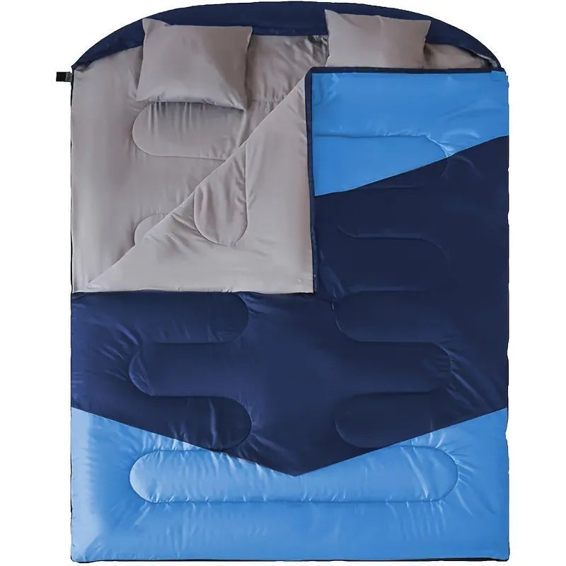 Seven-in-one pillow size sleeping bag in black double, folded to compact cushion shape on outdoor ground