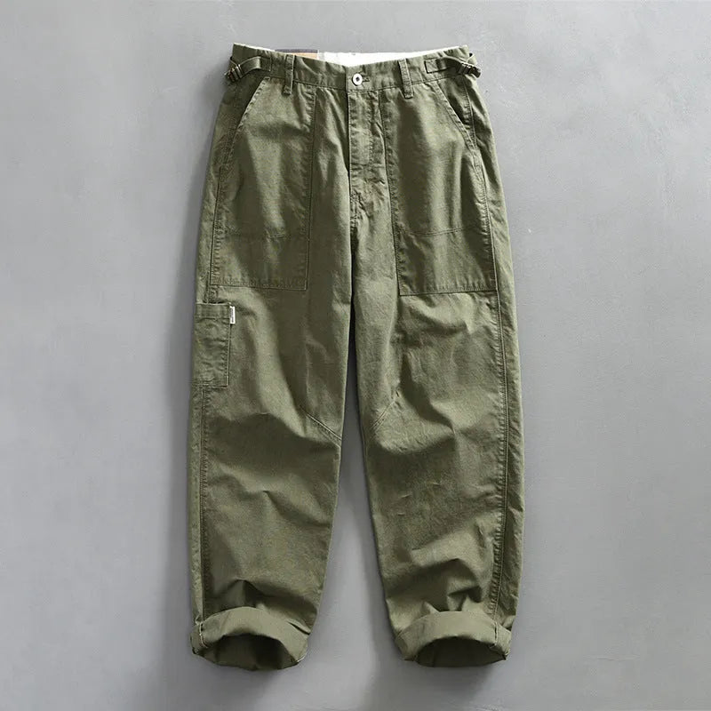 Men's straight-leg cotton trousers in apricot, shown laid flat to display the mid-waist and classic cut.