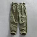 Men's straight-leg cotton trousers in apricot, shown laid flat to display the mid-waist and classic cut.