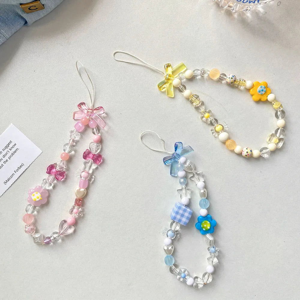 Yellow beaded mobile phone lanyard with a plastic flower charm on an adjustable strap.