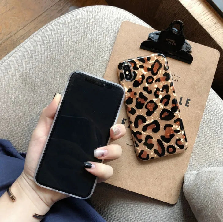 Leopard print silicone protective case for iPhone on a table.
