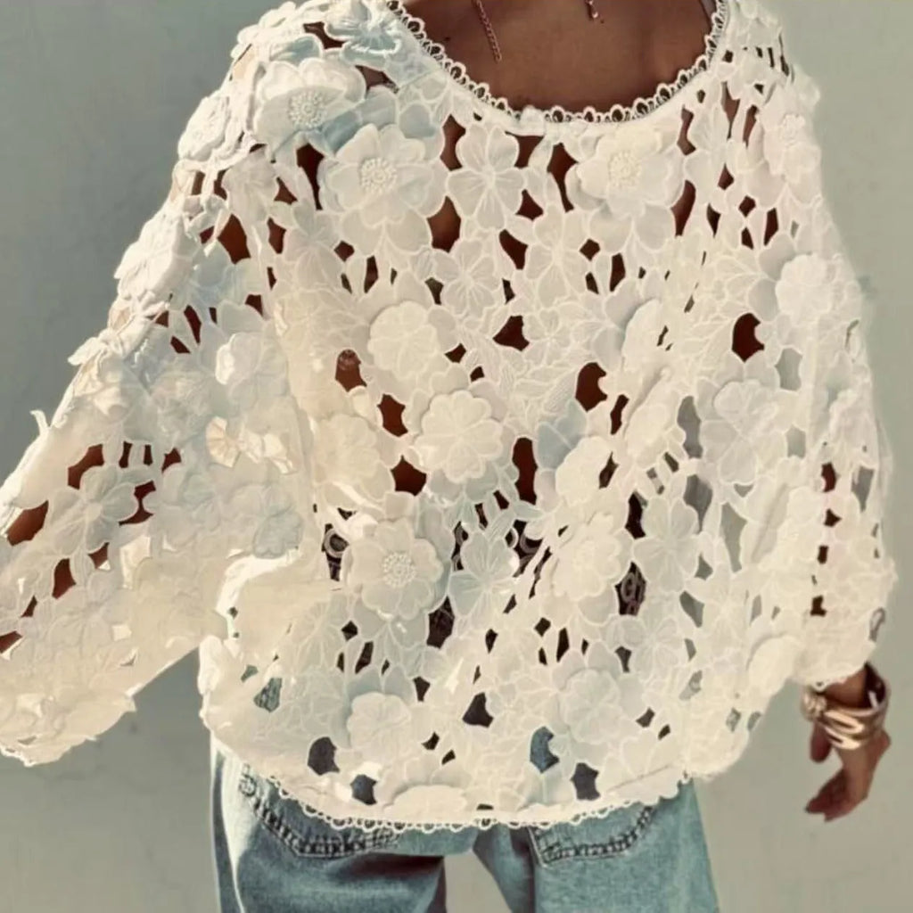 Loose fit white lace cardigan with black three-dimensional flower trim and a V-neck.