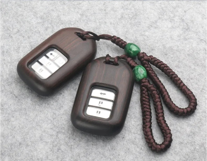 Solid ebony sandalwood key case with key rings, showing carved wood grain on a plain background