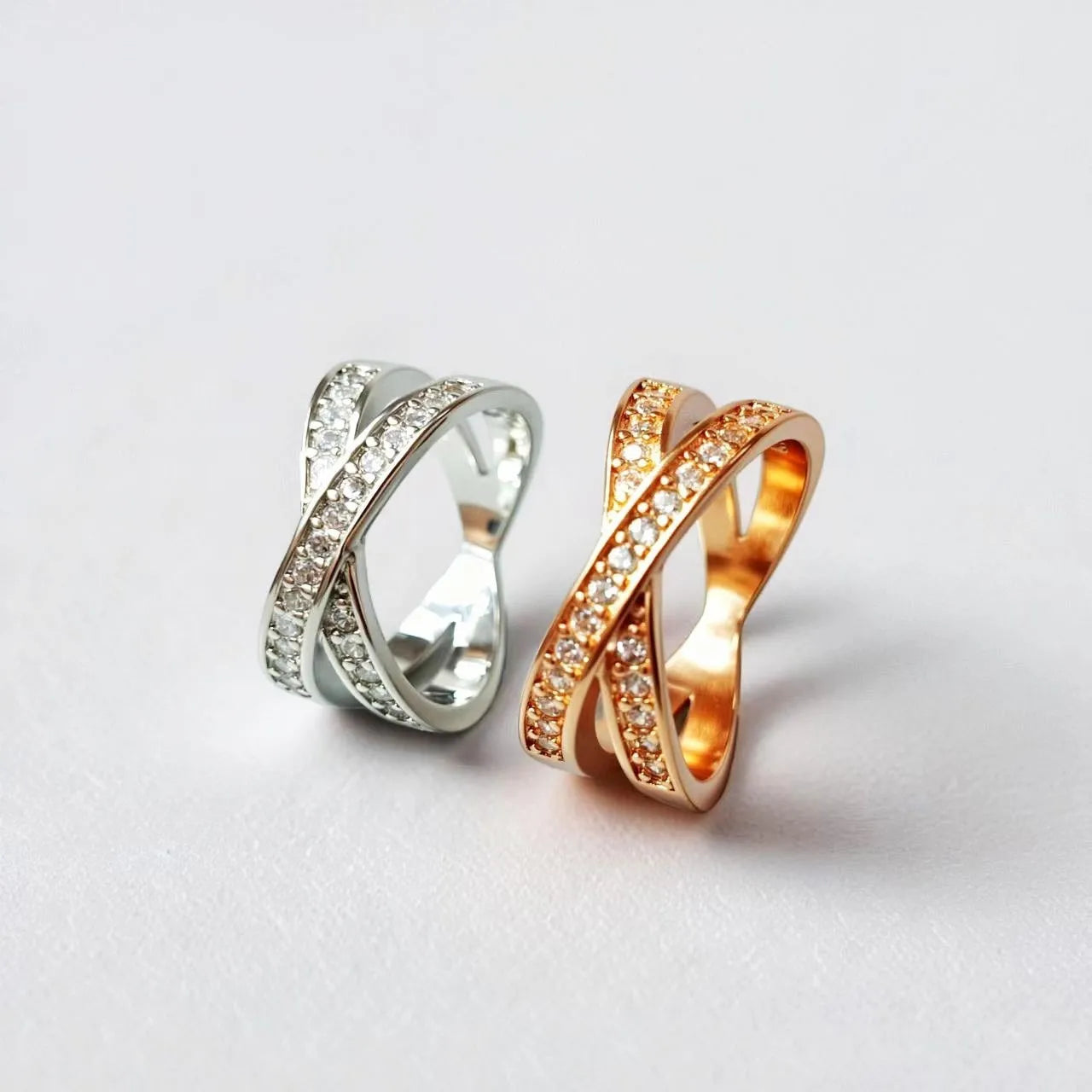 Simple silver cross ring with micro-inlaid zircon detail on a model's finger.