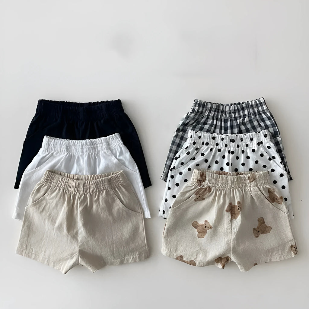 Baby loose thin cotton and linen shorts in black with elastic waist, side view on white background