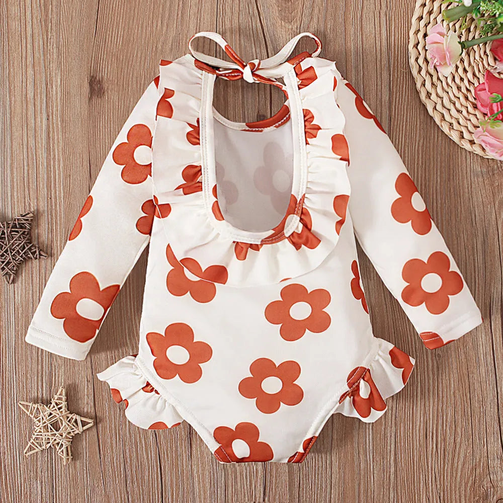 Girl's floral print swimsuit with crew neckline and open back design in orange colour