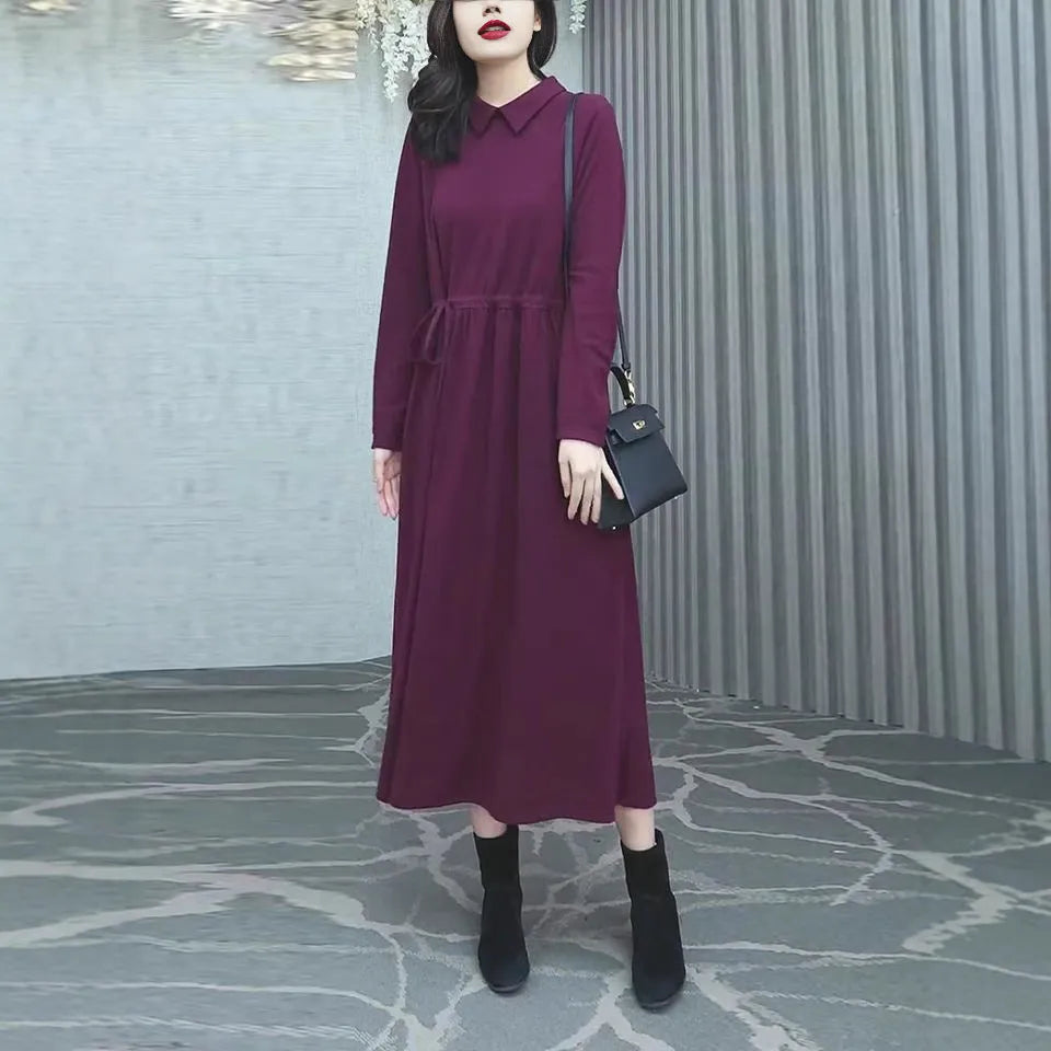 Purplish red women's plus size long sleeve dress with a long skirt on a hanger.