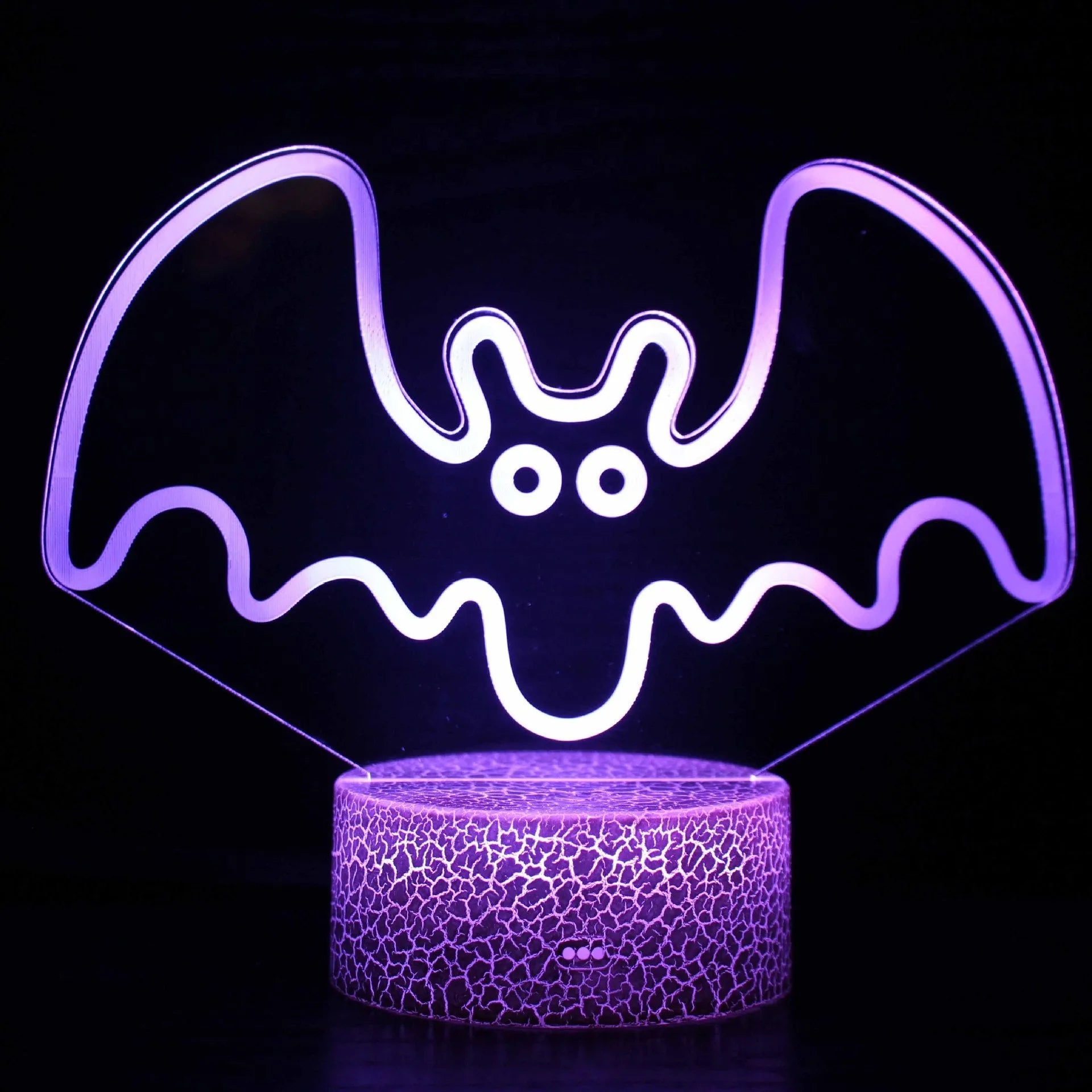 Acrylic USB touch night light with colourful crack base design on a bedside table.