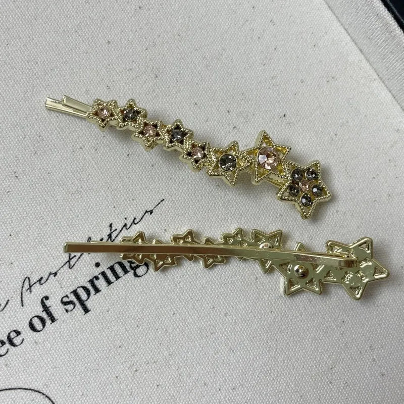 Gold alloy rhinestone barrette with a side clip, star decoration, and text.