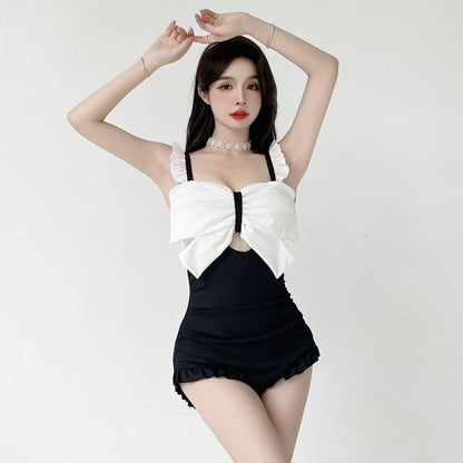 Women's one-piece swimsuit with adjustable bow detailing in solid colour