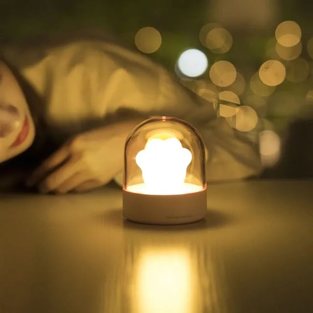 Grey cat paw shaped USB rechargeable night light with music box feature on wooden desk