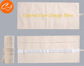 Canvas pencil wrap roll up case with multiple elastic bands holding pens and pencils, in a compact roll.