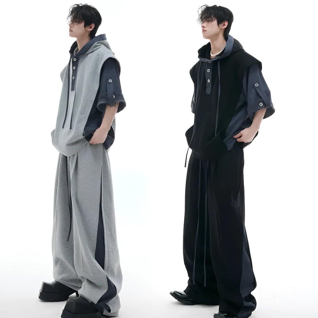 Man wearing a black hooded zip-up jacket and matching trousers from a heavy polyester tracksuit set.