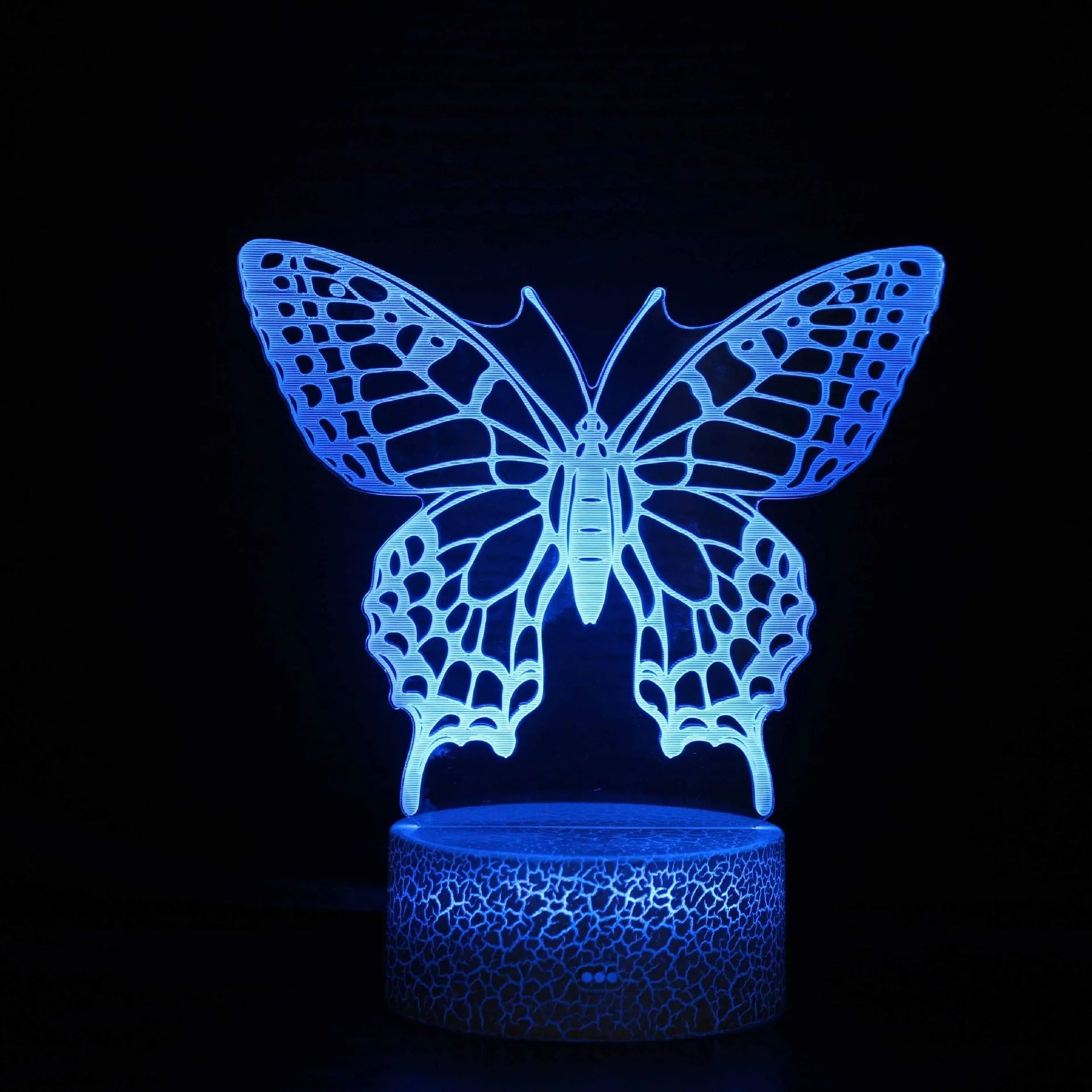 Acrylic USB touch night light with colourful crack base design on a bedside table.