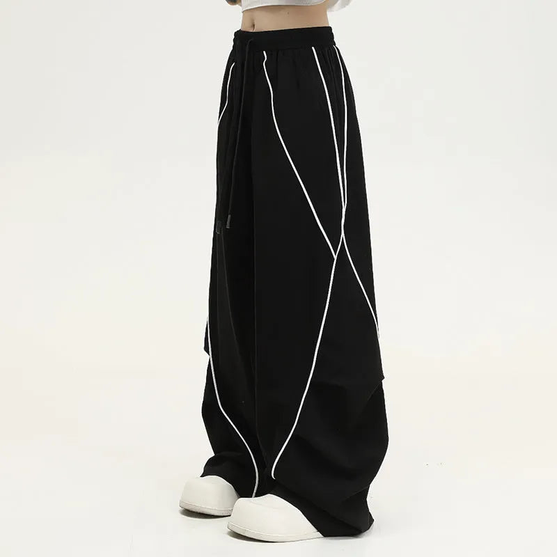 Black striped pleated wide-leg hip hop trousers on hanger showing mid-waist design