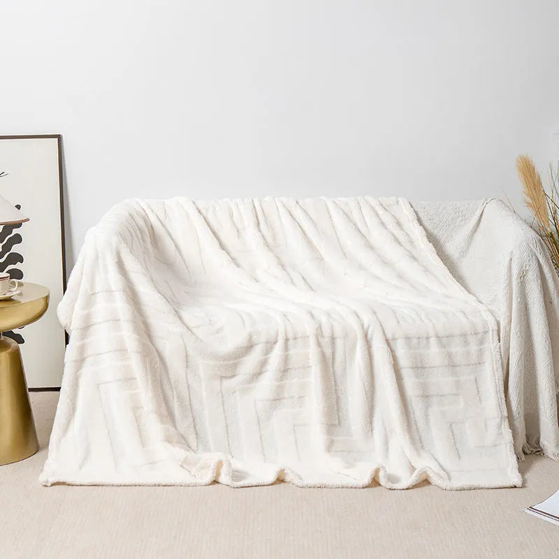Thick coral fleece square blanket in a modern solid colour, draped over a sofa.