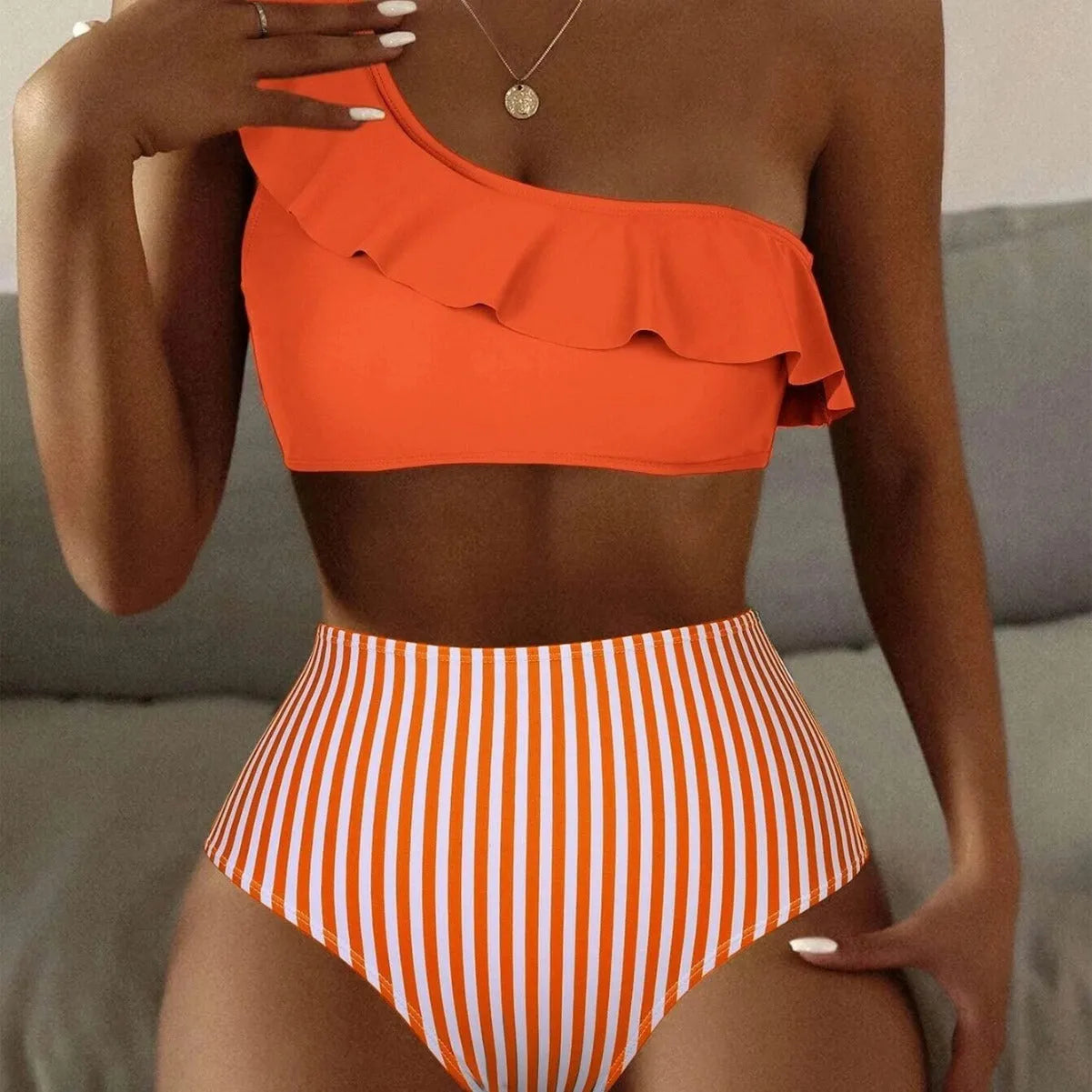 Women's striped and solid colour block bikini swimsuit on a hanger, shown in lavender purple.