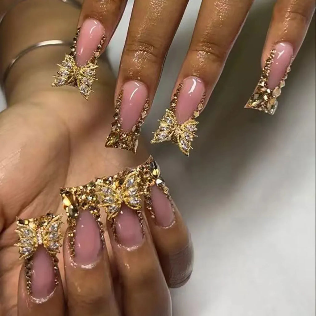 Golden diamond and butterfly design nail stickers on nails with debris texture, part of a 24-piece DIY kit.