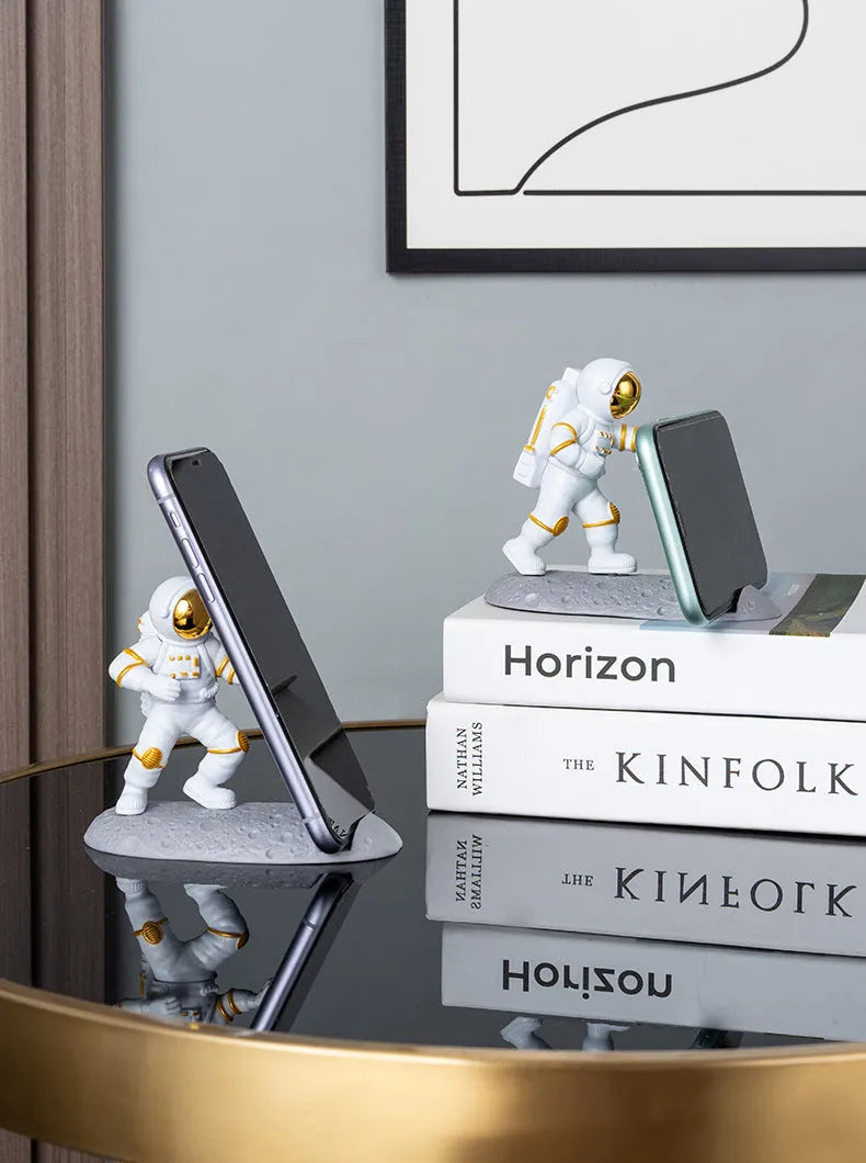 Plastic astronaut decoration mobile phone holder in blue colour on a desk