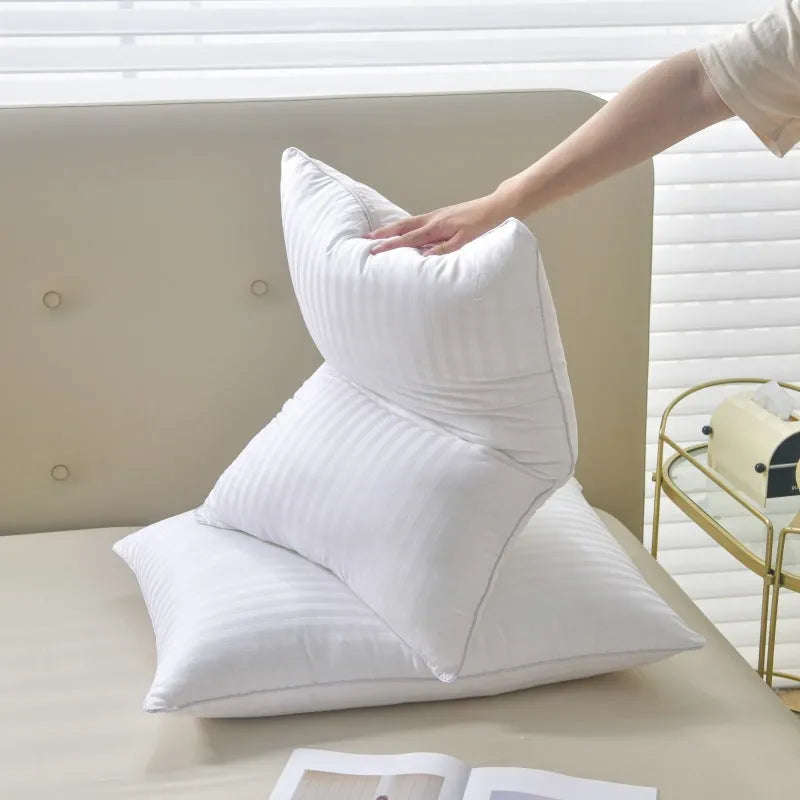 White cotton satin stripe feather and cotton pillow shown in a simple style on a bed.