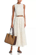 White women's sleeveless top and long skirt suit set with retro embroidery details.