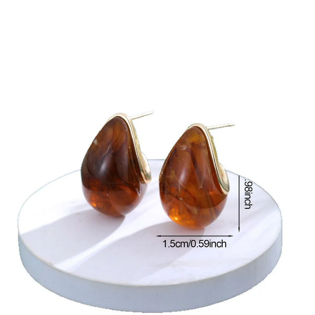 Water droplet retro earrings in brown colour with shiny pendant on white background