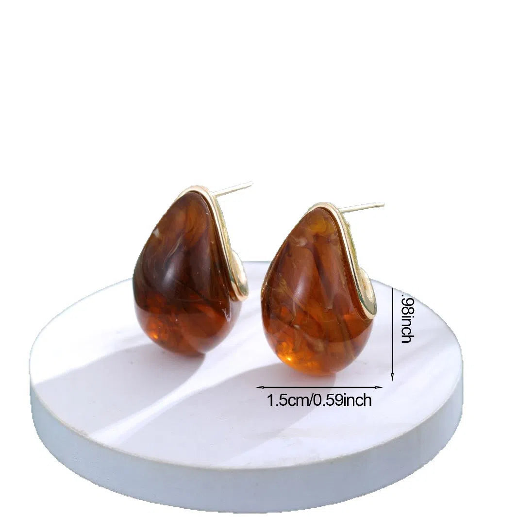 Water droplet retro earrings in brown colour with shiny pendant on white background