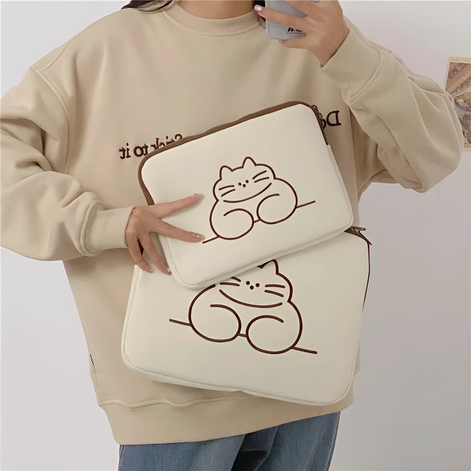 Nylon tablet protective sleeve with embroidered cat design and zip opening.