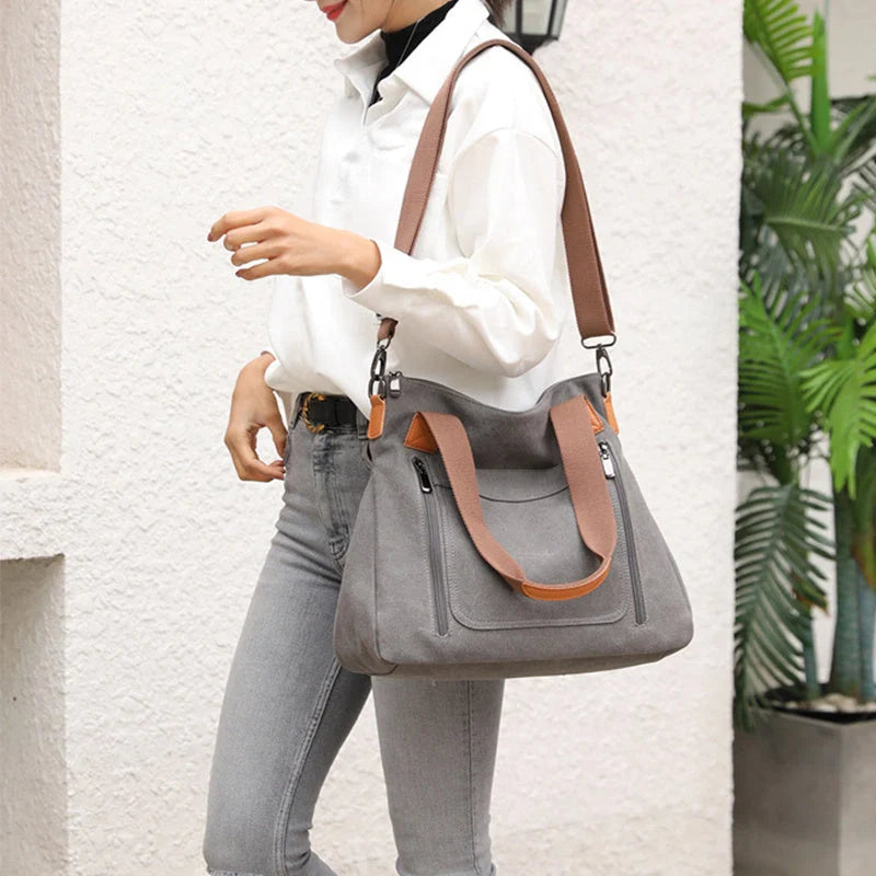 Women's canvas shoulder bag in multiple colours, showcasing spacious interior and zipper closure.