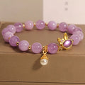 Natural mauve jade rabbit bracelet with crystal band and purplish red hare head charm.
