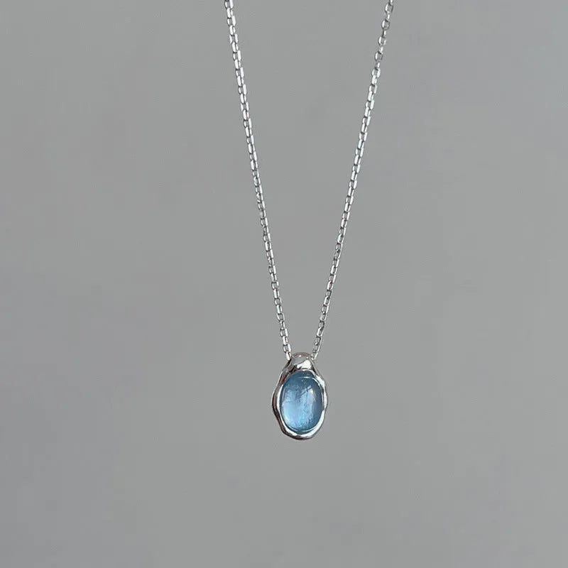 Geometric navy blue water droplet pendant necklace on a platinum-coloured adjustable chain.