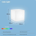 A modern white LED cube light stool sitting outdoors on a patio.