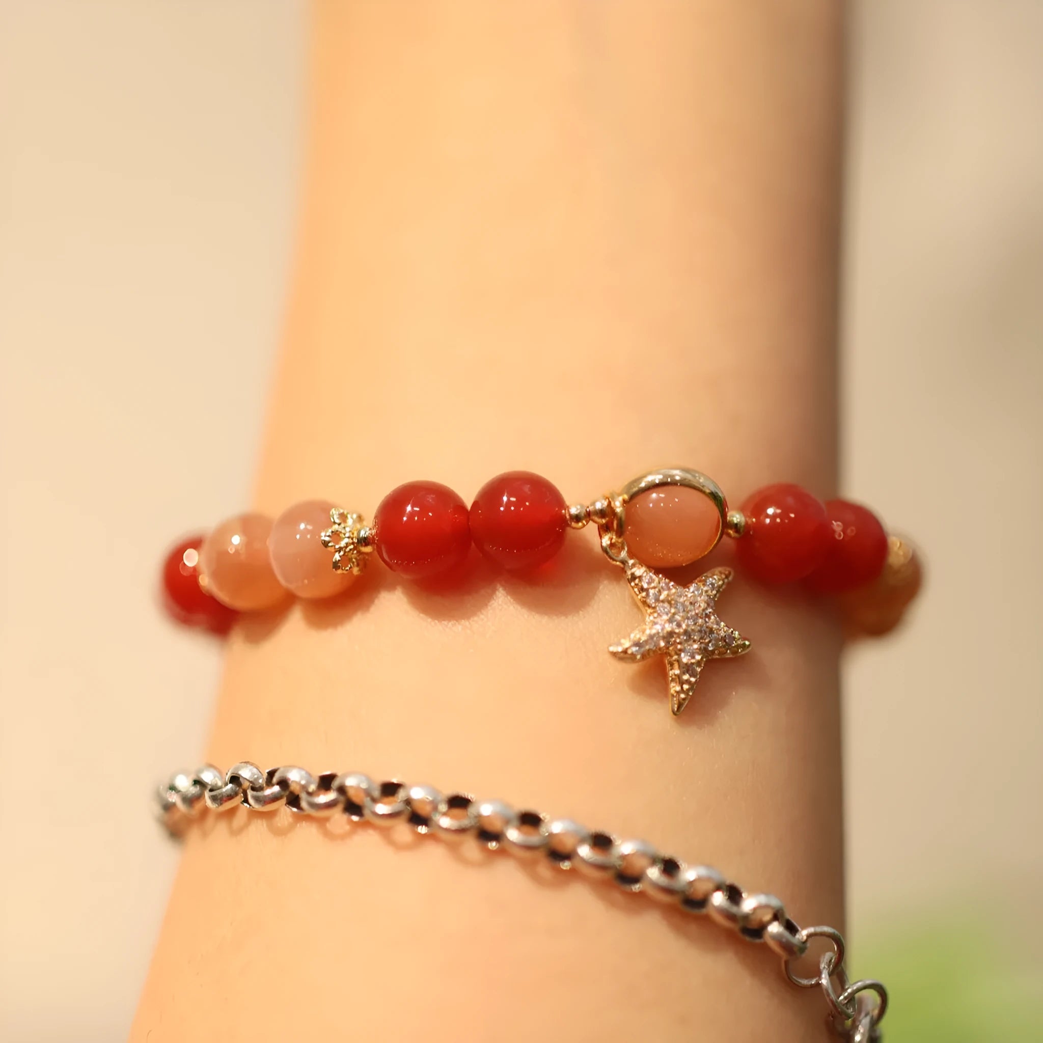 Handmade women's bracelet with 8mm red agate and sunstone beads in ethnic XINGX design featuring star and xiangyun elements
