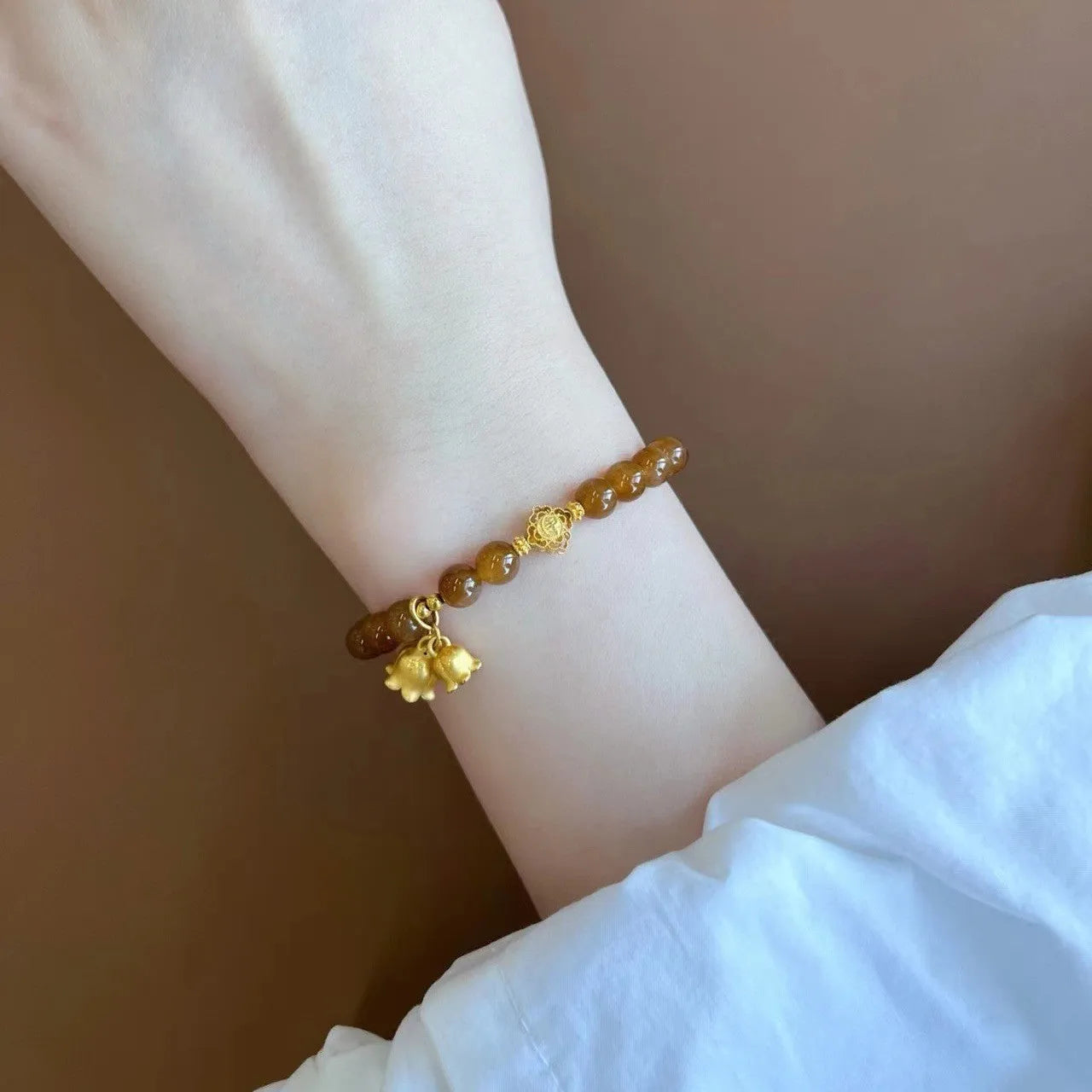 Women's natural stone Lily bracelet with electroplated finish and floral design in caramel beeswax colour