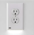 White plug-in LED socket night light installed in a wall socket, showing automatic sensor.