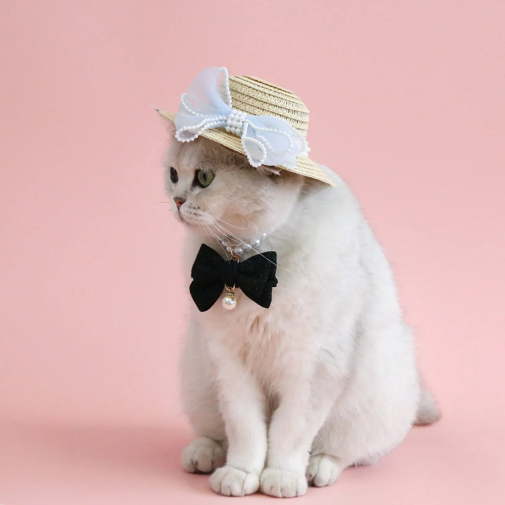 Pink pearl bow straw hat for a cat on a mannequin head, showing Lafite leaf weave and butterfly detail.