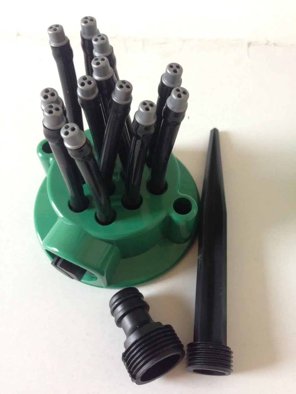 Green adjustable lawn sprinkler with flexible bendable watering nozzles on a 9cm base.