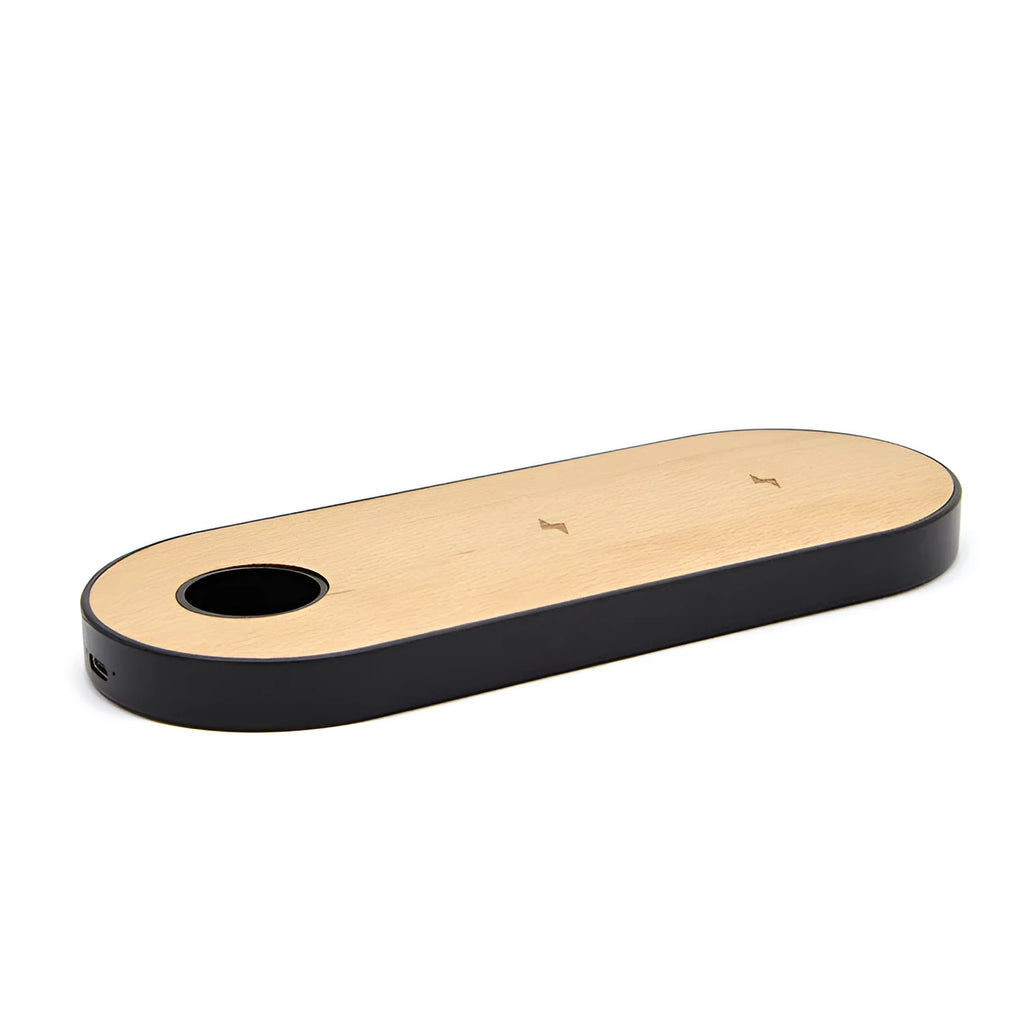 A wooden wireless charging pad made from bamboo with beech wood edging on a desk.