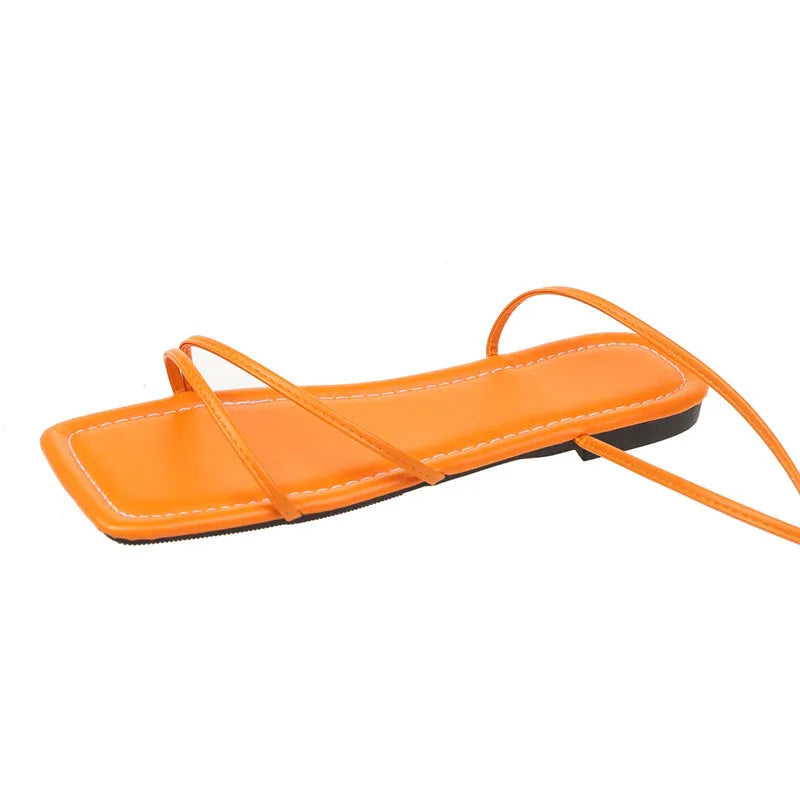 Women's flat sandals with ankle wrap strap and square toe in black, white, and orange colours.