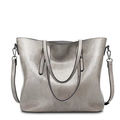 Black oil leather tote bag with square shape, zipper top, soft handle, and internal pockets for winter use