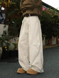 Men's pleated straight-leg trousers in a loose fit, shown in apricot colour with striped pattern.