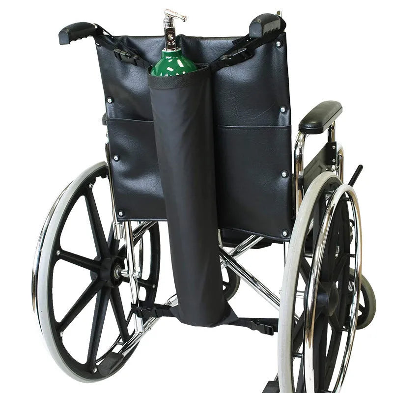 Black cylindrical Oxford cloth pannier bag attached to a wheelchair for oxygen cylinder carriage.