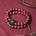 Handmade double circle charm bracelet strung with brown bodhi seeds on a white background.