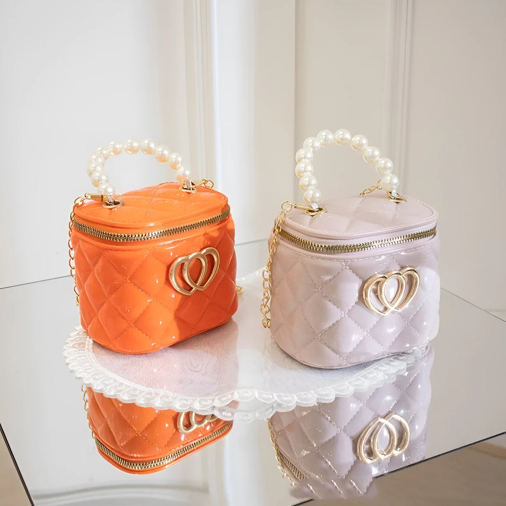 Women's PVC bucket gel handbag in apricot colour, showing heart-shaped pattern on lining.