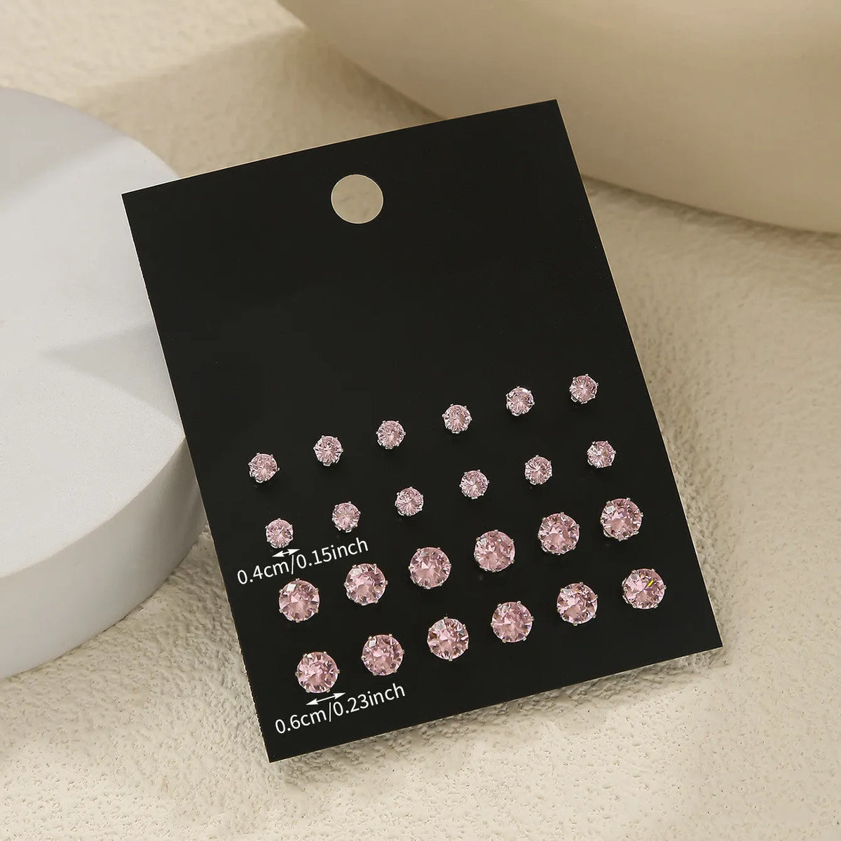 Pink round women's earrings set with 12 pairs of alloy electroplated geometric studs on display