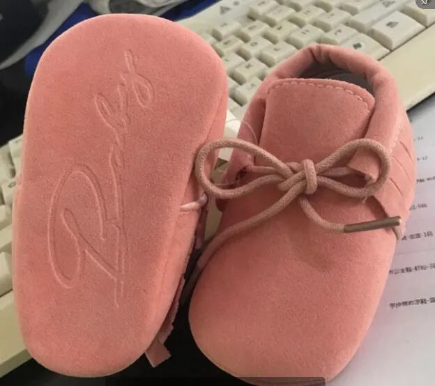Pair of baby shoes with tassel and polychromatic sanding finish in a colourful pattern on soft sole