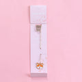 Colourful metal bookmark with a small cartoon pendant charm, showing panda and rocket design options.