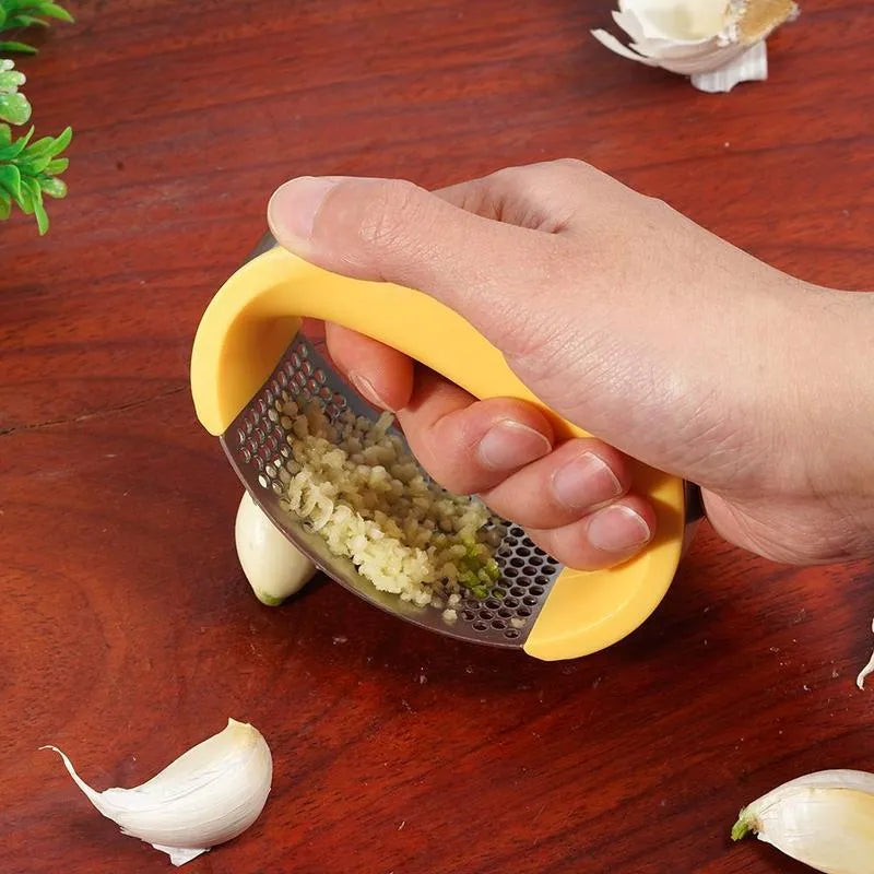 Stainless steel garlic press with curved ergonomic design and non-slip handle in assorted colours.