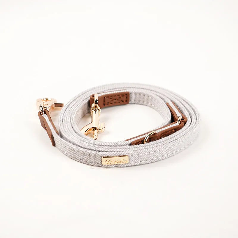 Adjustable mohair dog collar with nameplate and hand holding rope in cement gray