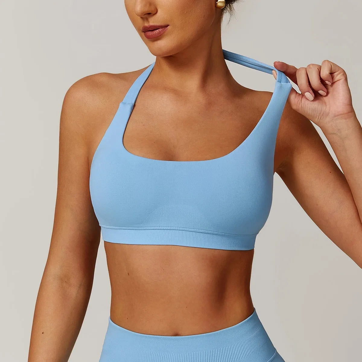 Women's black halter sports bra with hollow back and removable padding for yoga and workouts.